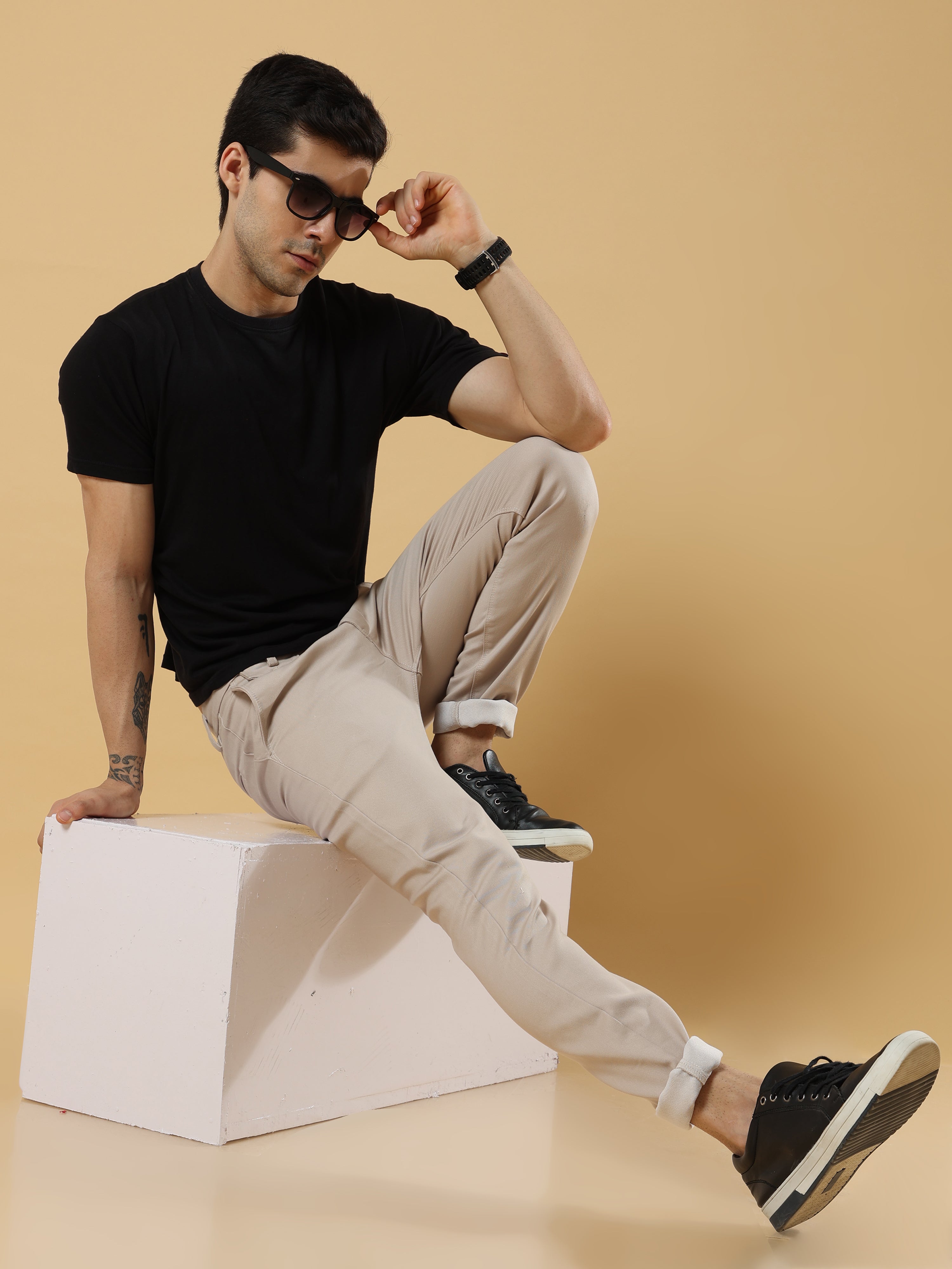 How can men pair relaxed fit trousers with shirts, T-shirts, and footwear for office, travel, and casual outings?