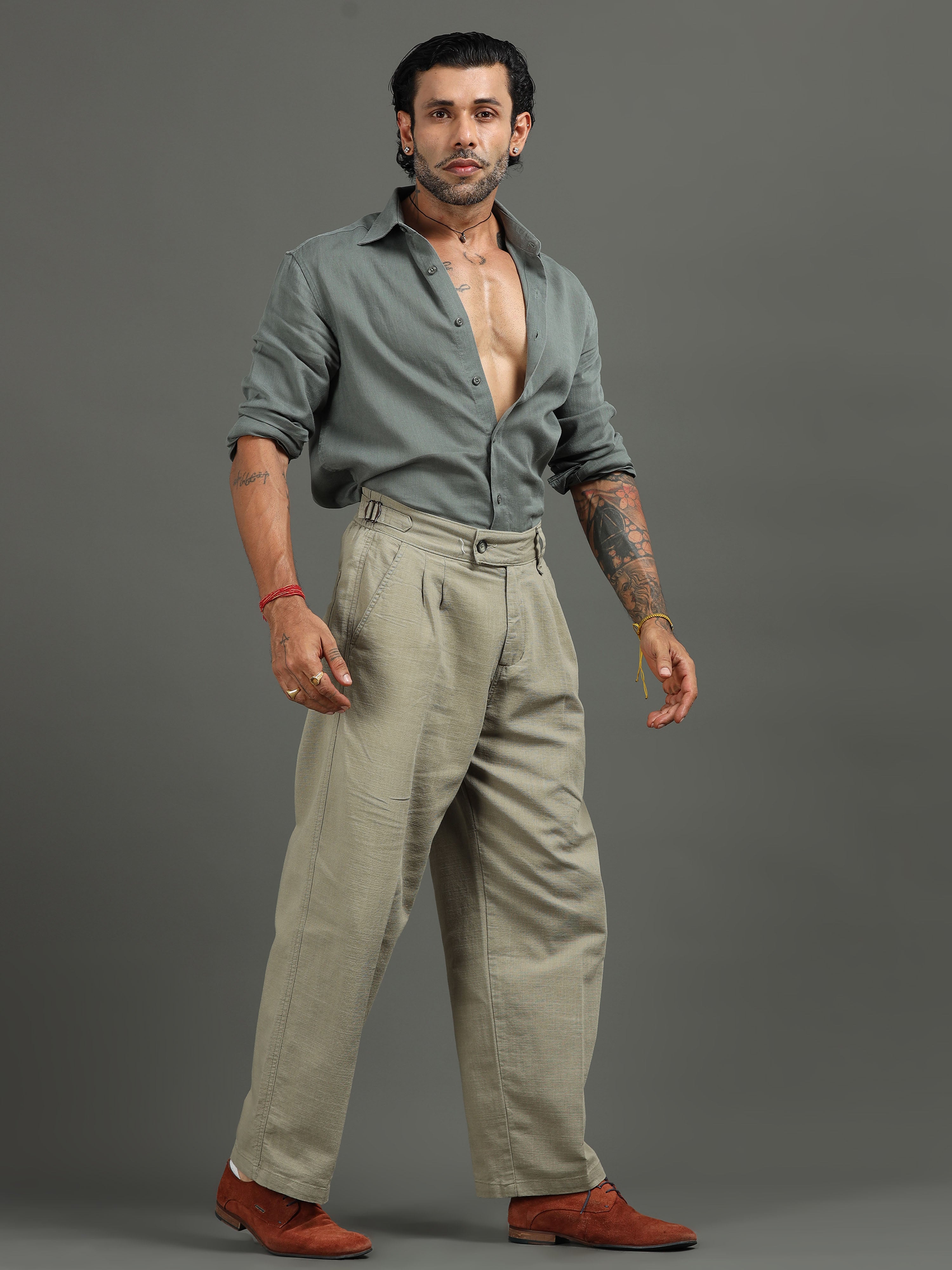 Man wearing pleated relaxed trousers styled with a shirt for smart casual everyday comfort.